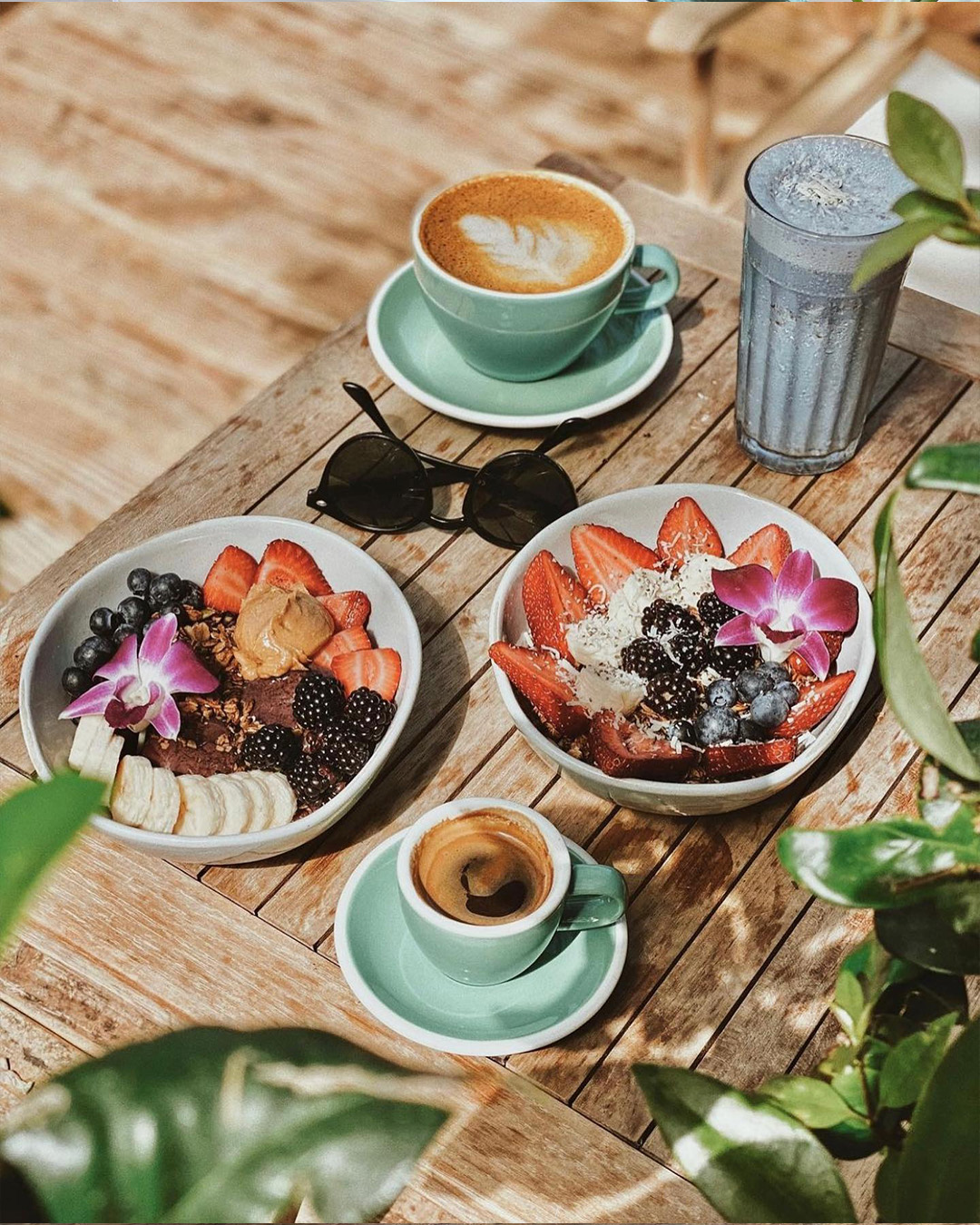 Acai bowls, espresso and a smoothie on the sunny patio table